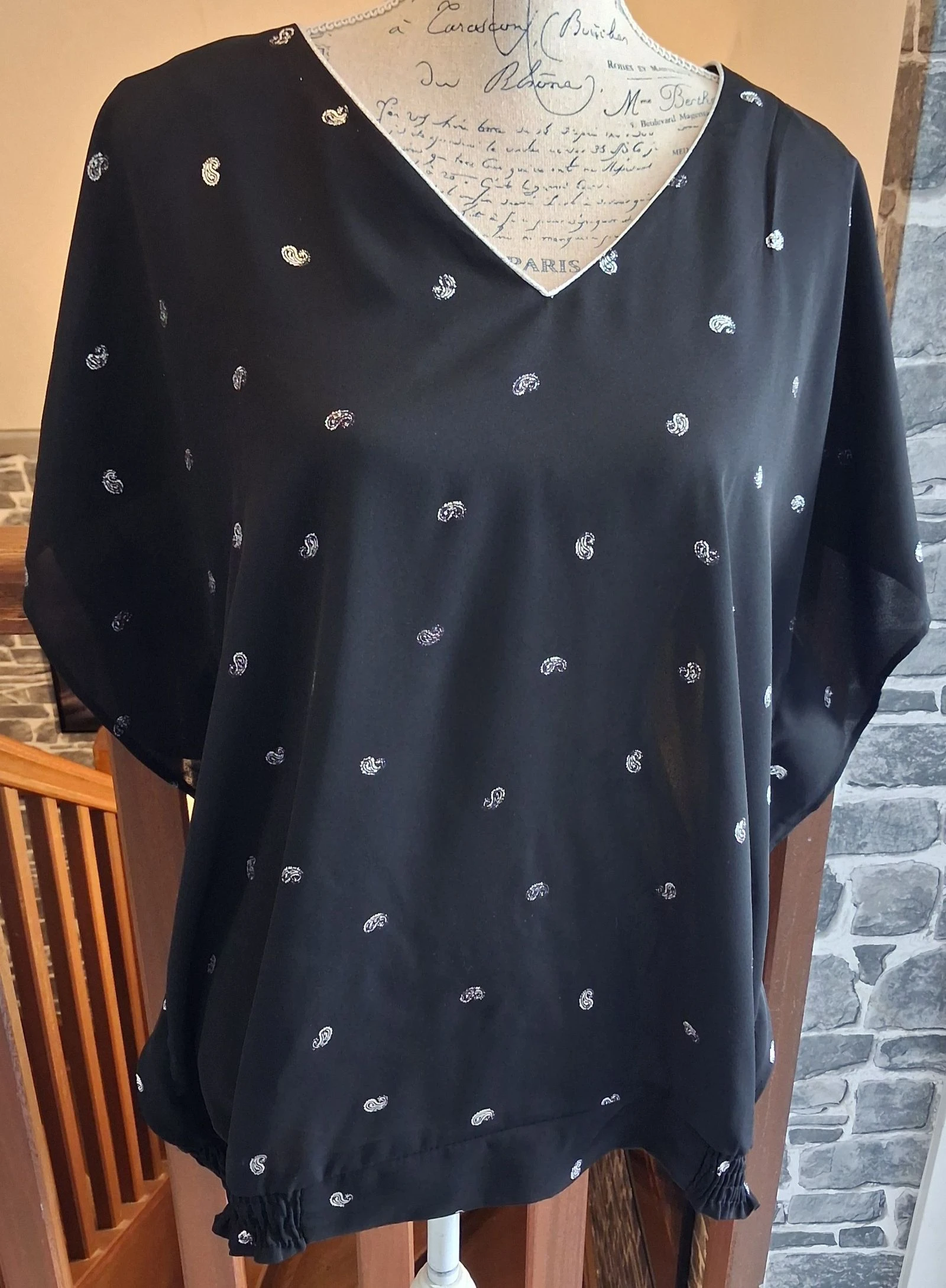 Blouse noire au col et aux motifs argentés